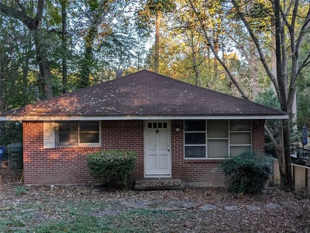a front view of house with yard and trees around