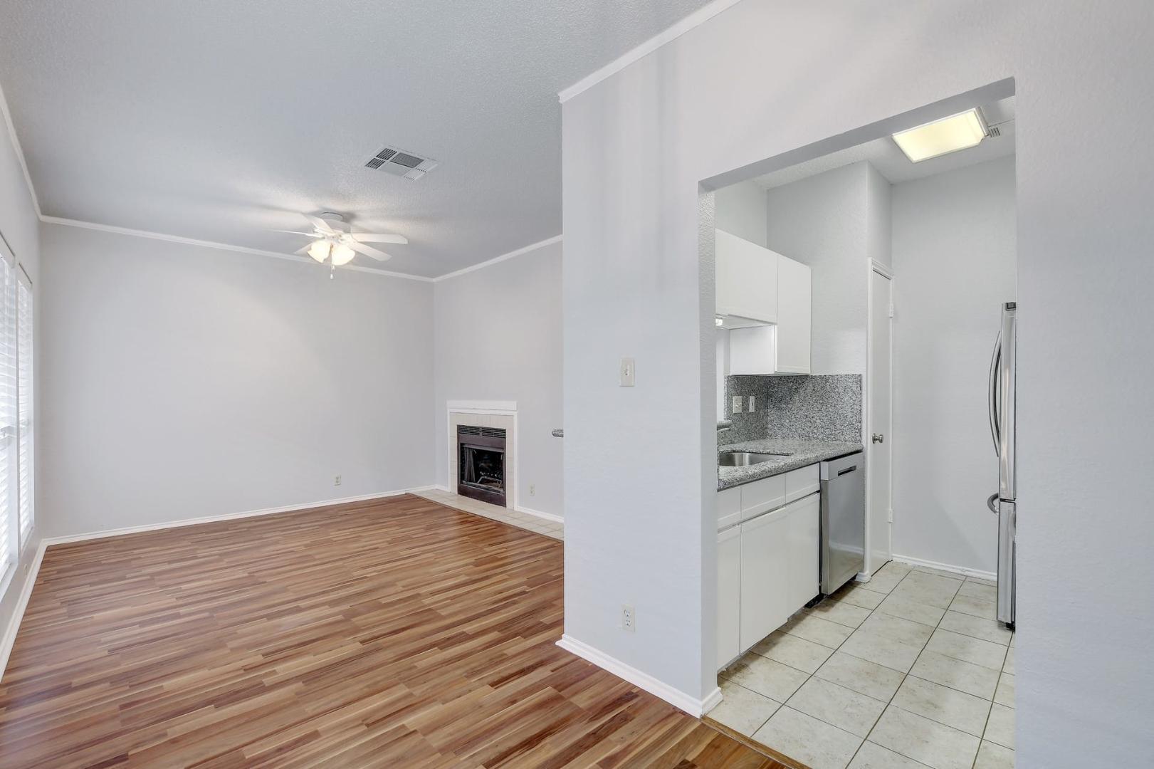 2804 Rio Grande Street, Unit 310 Austin, TX 78705 - Photo 6 of 22 Warm wood floors complement a modern kitchen, creating an inviting living space.