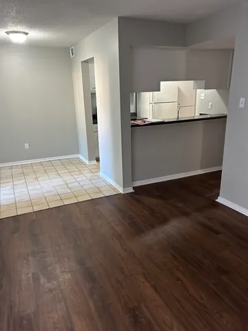 a view of an empty room with wooden floor and closet