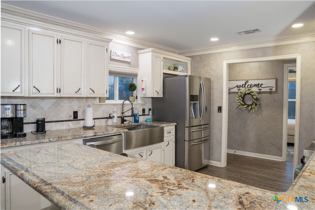 582 Cypress Valley Road Cuero, TX 77954 - Photo 20 of 46 a kitchen with stainless steel appliances granite countertop a refrigerator a stove and a sink