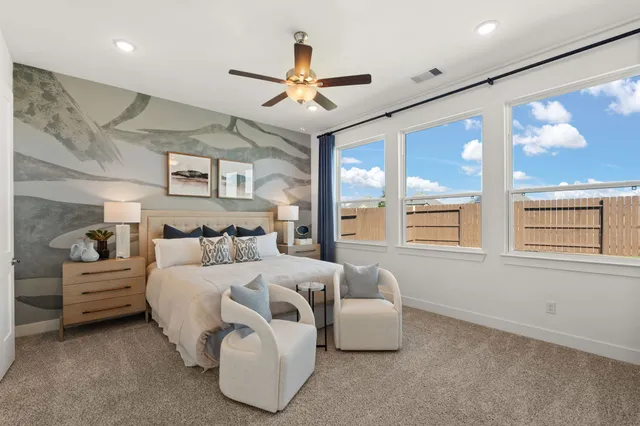 a bedroom with furniture and large window