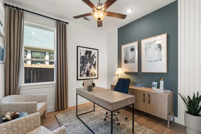 a view of a workspace with furniture and a window