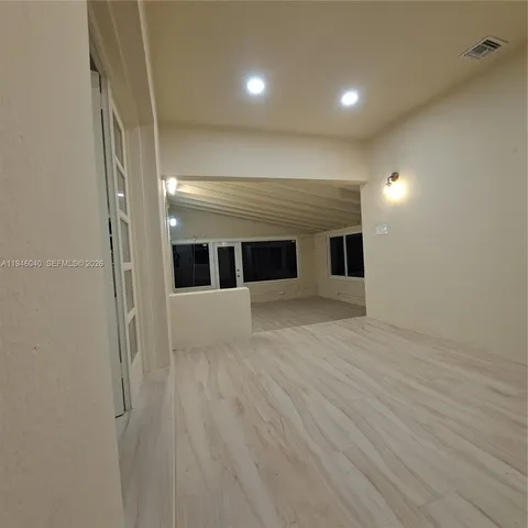 a view of empty room with wooden floor
