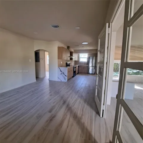 a view of a living room hardwood floor and a kitchen