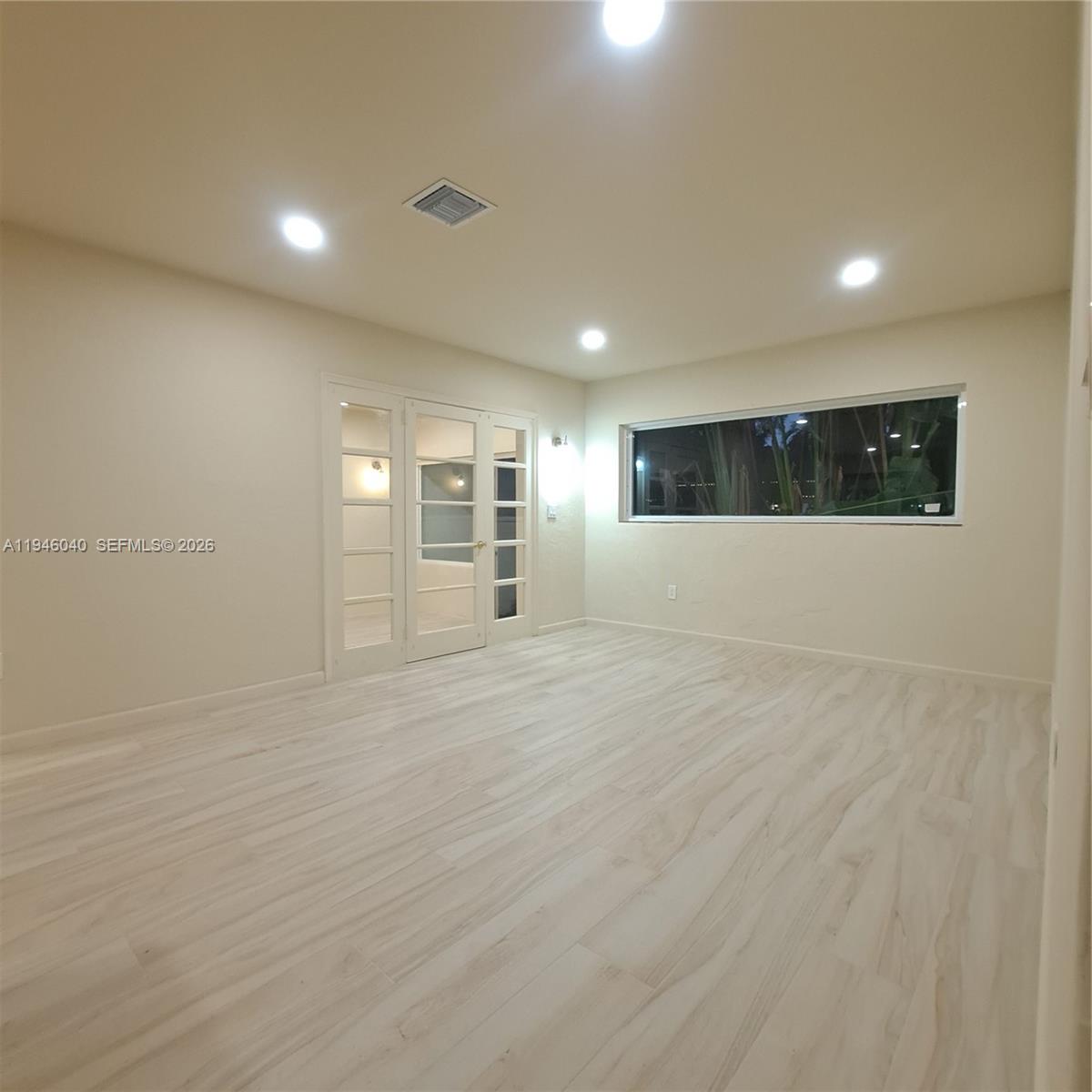 5840 Southwest 51st Street Miami, FL 33155 - Photo 7 of 15 an empty room with wooden floor and windows