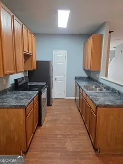 a kitchen with granite countertop a sink stove and cabinets