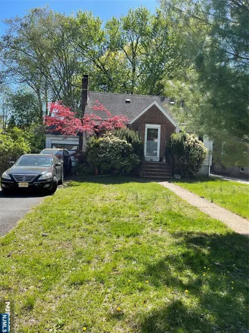 a front view of house with yard and trees
