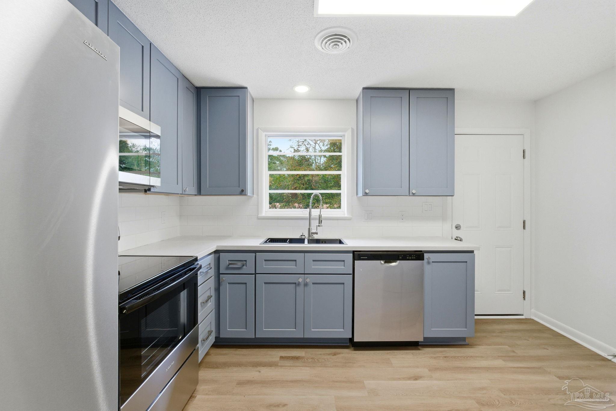 6534 Berryhill Road Milton, FL 32570 - Photo 11 of 38 a kitchen with stainless steel appliances granite countertop a sink a stove a refrigerator and island