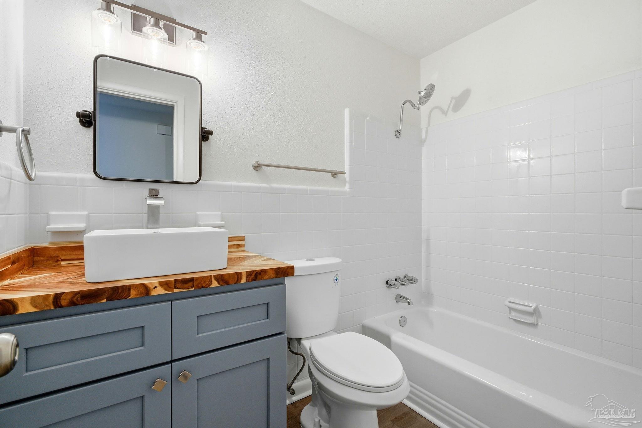 6534 Berryhill Road Milton, FL 32570 - Photo 13 of 38 a bathroom with a granite countertop toilet sink and mirror