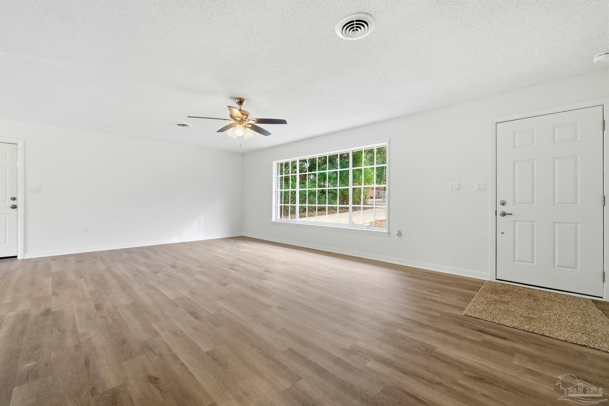 6534 Berryhill Road Milton, FL 32570 - Photo 15 of 38 an empty room with windows and a ceiling fan