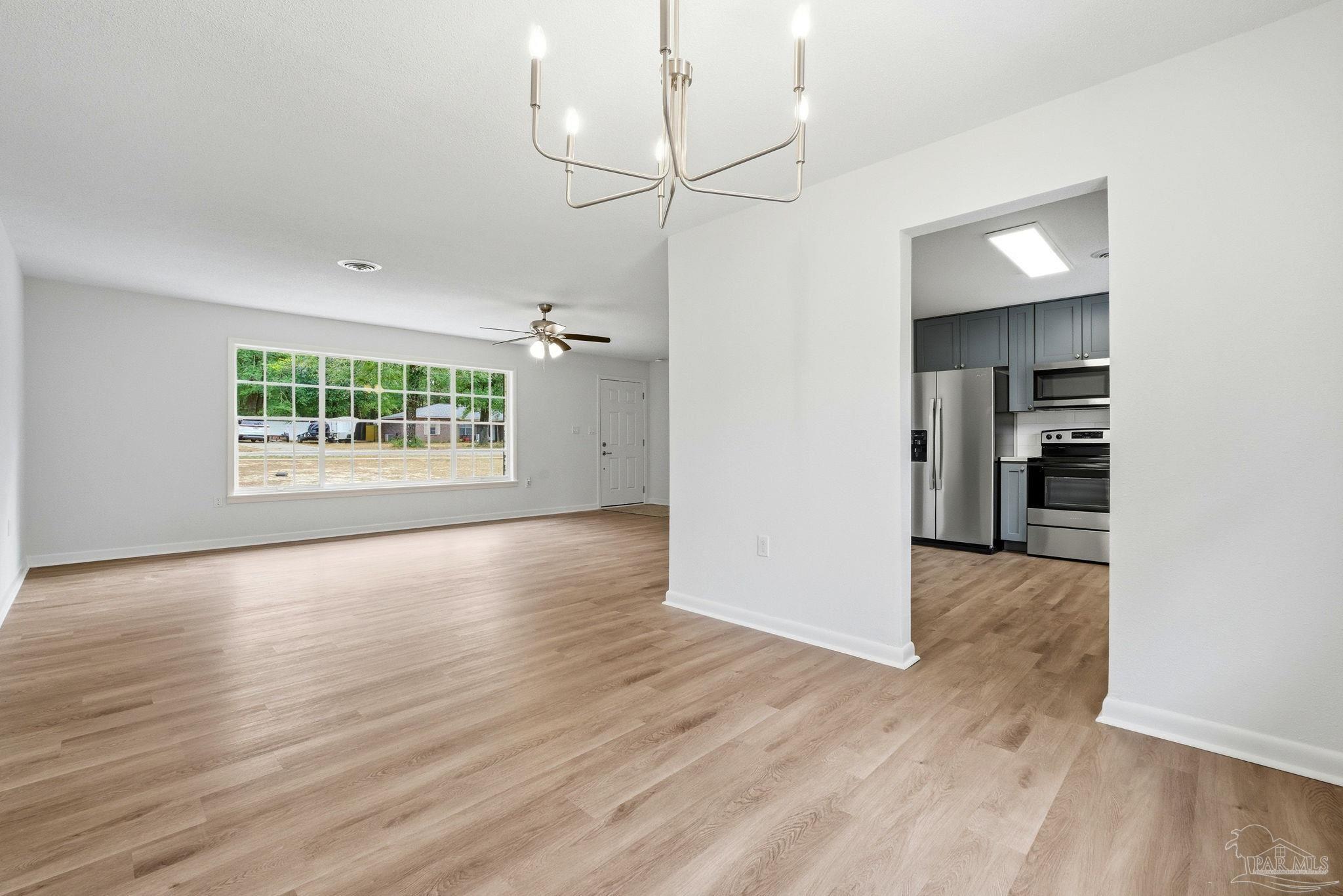 6534 Berryhill Road Milton, FL 32570 - Photo 19 of 38 an empty room with wooden floor cabinet and windows