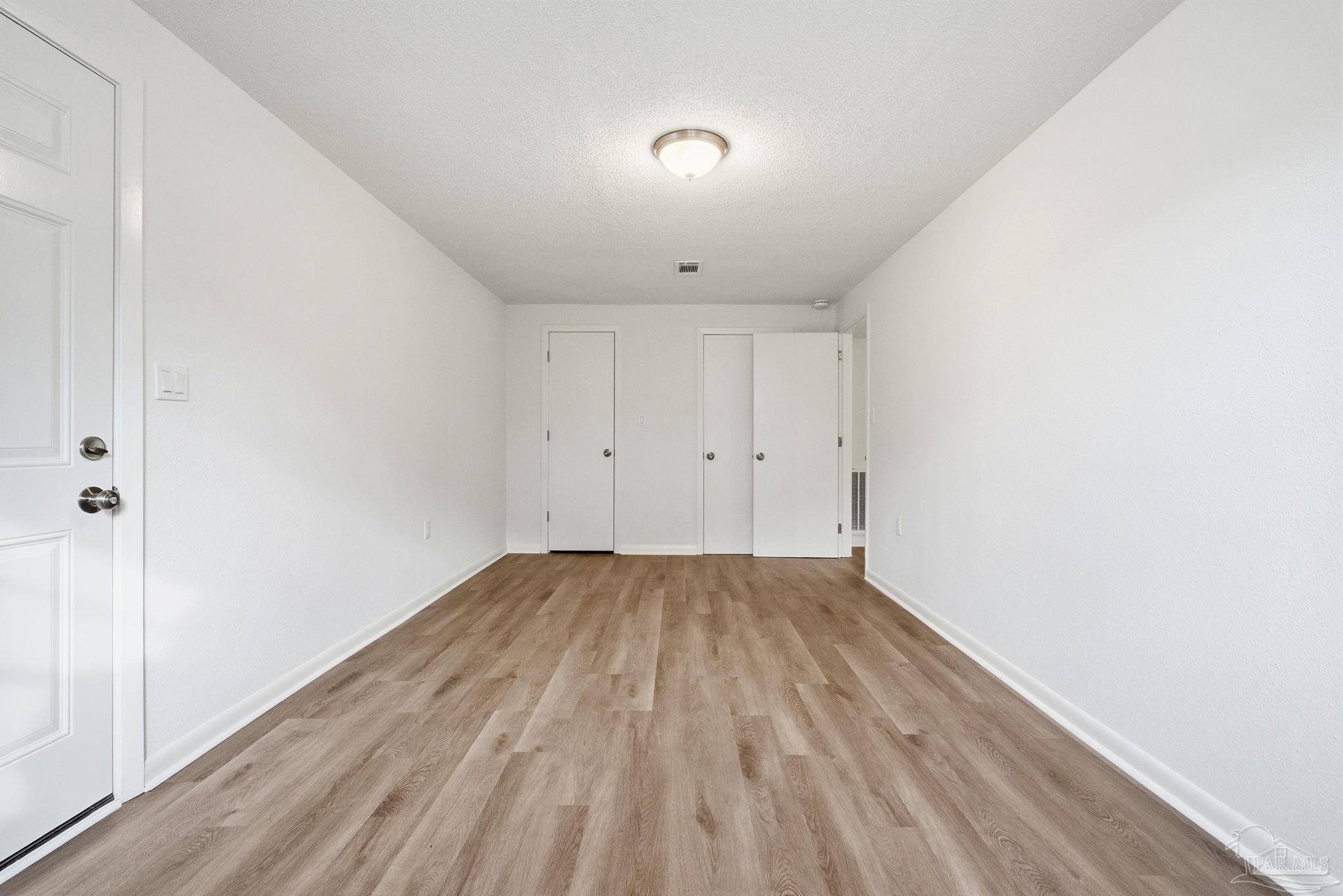 6534 Berryhill Road Milton, FL 32570 - Photo 25 of 38 a view of an empty room with wooden floor