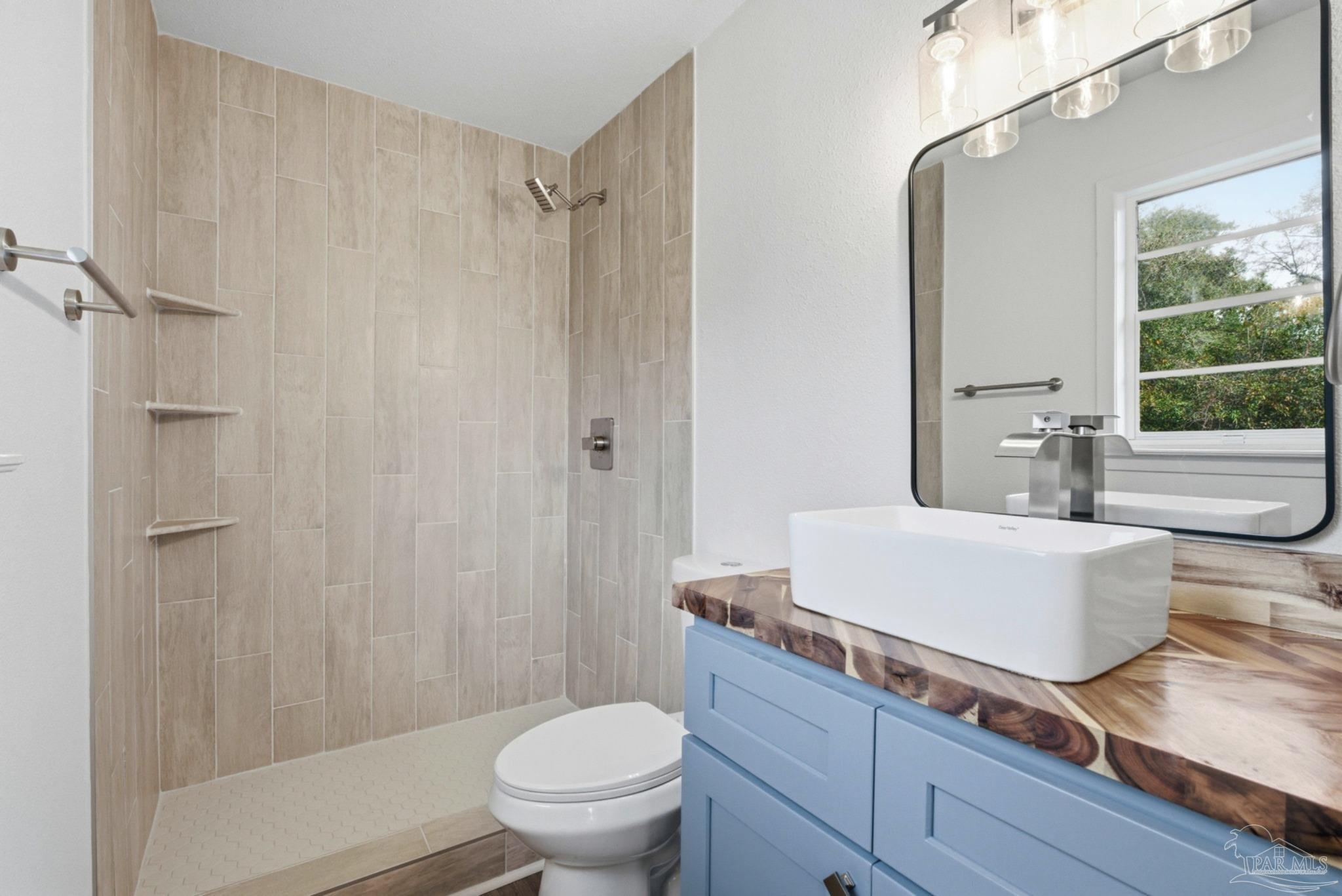 6534 Berryhill Road Milton, FL 32570 - Photo 8 of 38 a bath room with a toilet a sink and a bath tub