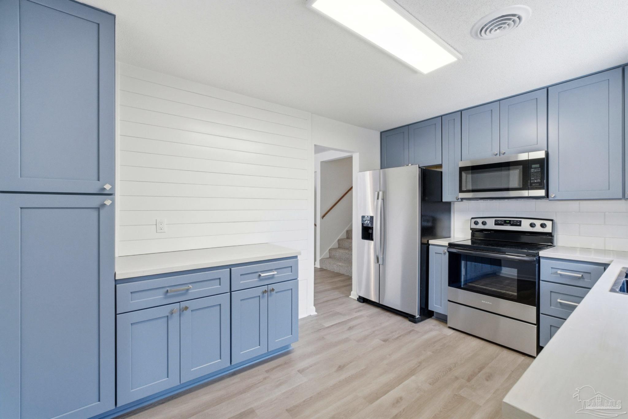 6534 Berryhill Road Milton, FL 32570 - Photo 9 of 38 a kitchen with wooden cabinets and stainless steel appliances