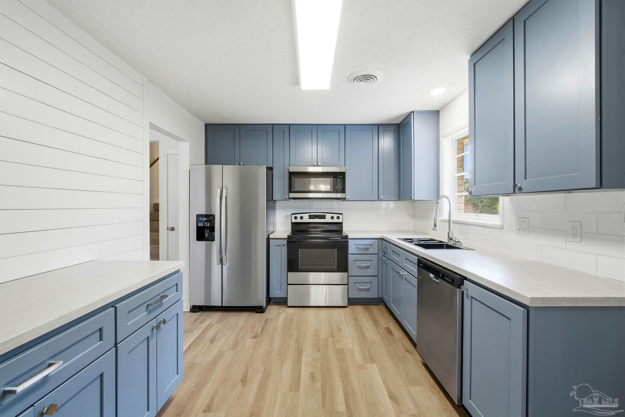 6534 Berryhill Road Milton, FL 32570 - Photo 10 of 38 a kitchen with a sink stainless steel appliances and cabinets