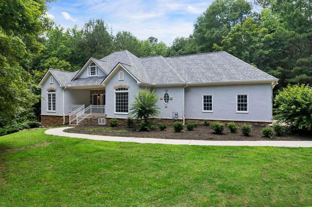 a front view of a house with garden and yard