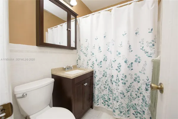 a bathroom with a granite countertop sink and a toilet