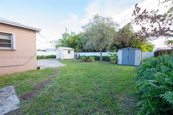 a view of a house with backyard and a sitting area