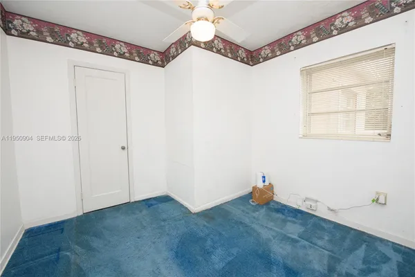 a view of a room with window and chandelier fan