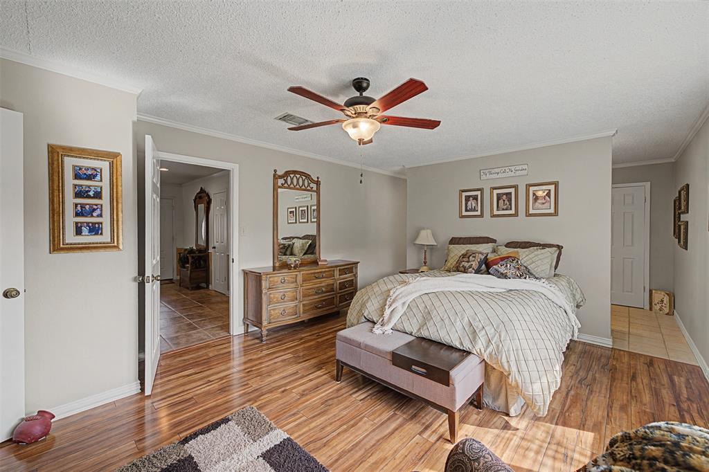 8240 Kramer Street Burleson, TX 76028 - Photo 16 of 39 a spacious bedroom with a bed and wooden floor
