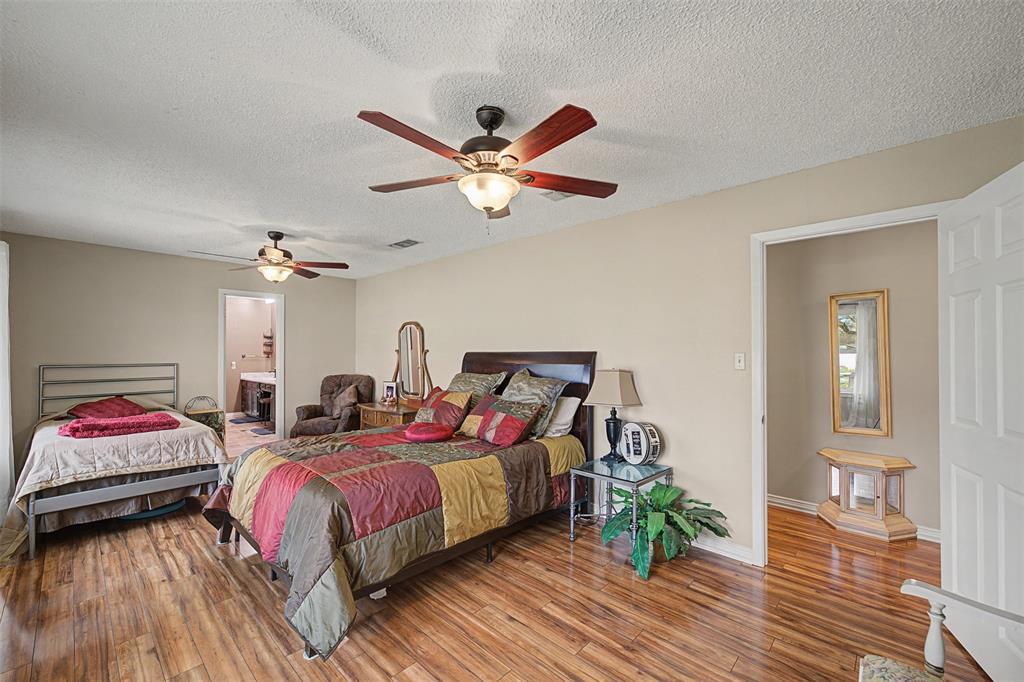 8240 Kramer Street Burleson, TX 76028 - Photo 21 of 39 a bedroom with bed and a chandelier