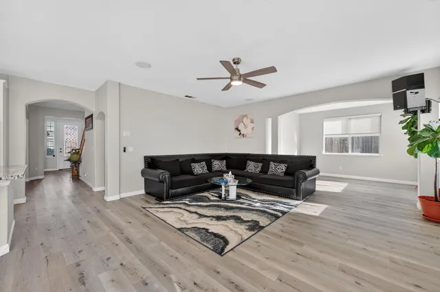 a living room with furniture a window and wooden floor