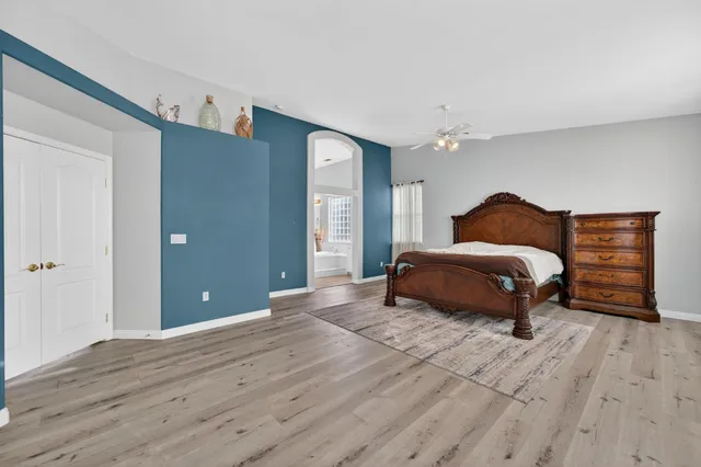 a spacious bedroom with a bed and a dresser