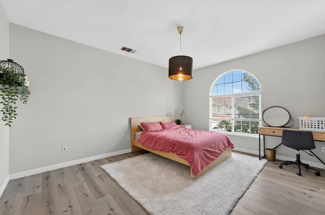 a spacious bedroom with a bed and a table in it