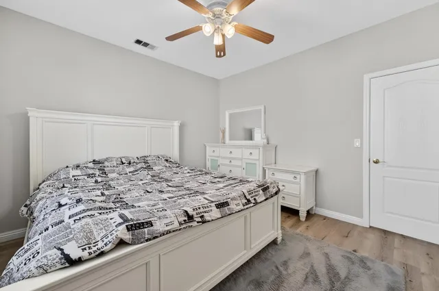 a spacious bedroom with a bed and a chandelier