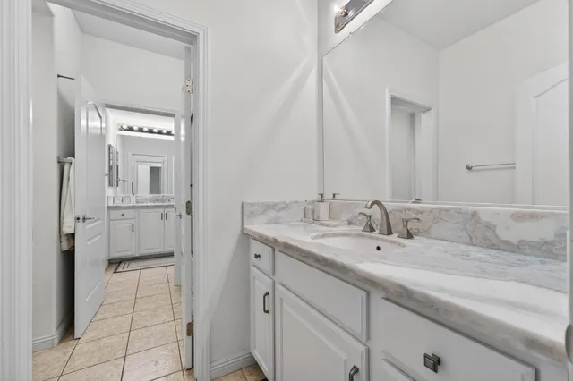 a en suite bathroom with a granite countertop sink and a mirror