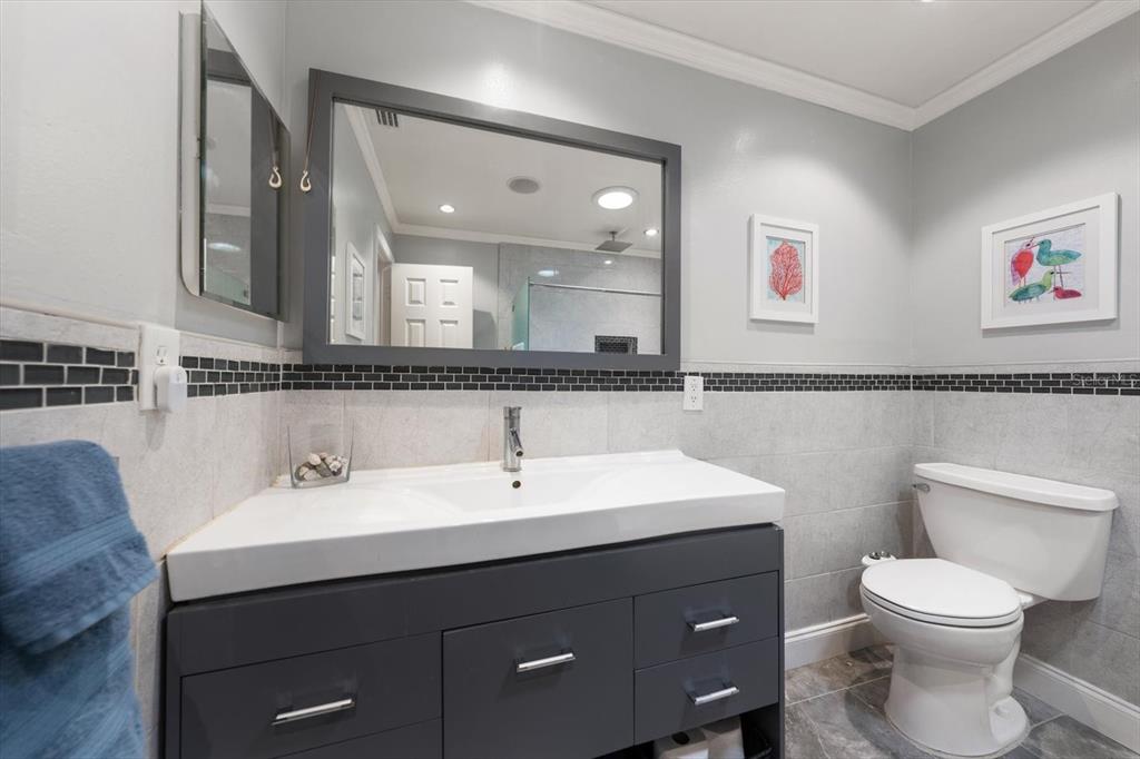 1921 Cardinal Road Dunedin, FL 34698 - Photo 28 of 52 a bathroom with a toilet a sink and mirror