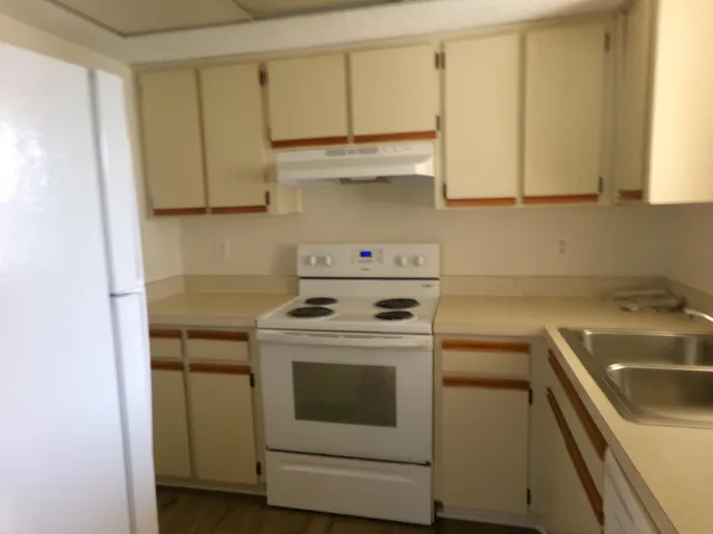a kitchen with a sink a stove and cabinets
