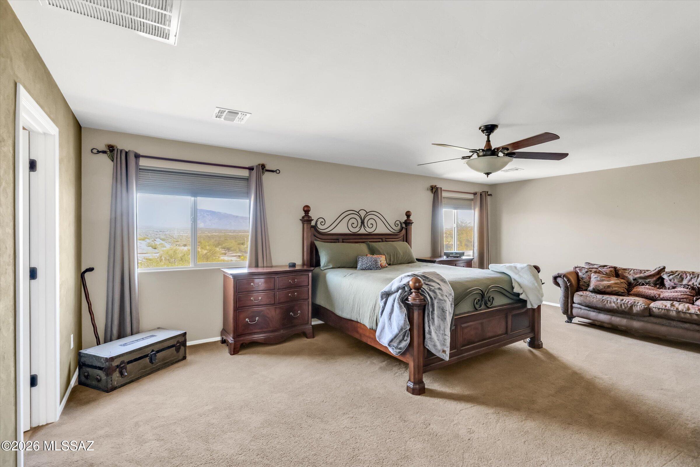 6095 South Jakemp Trail Tucson, AZ 85747 - Photo 25 of 52 a bedroom with a bed and a chandelier