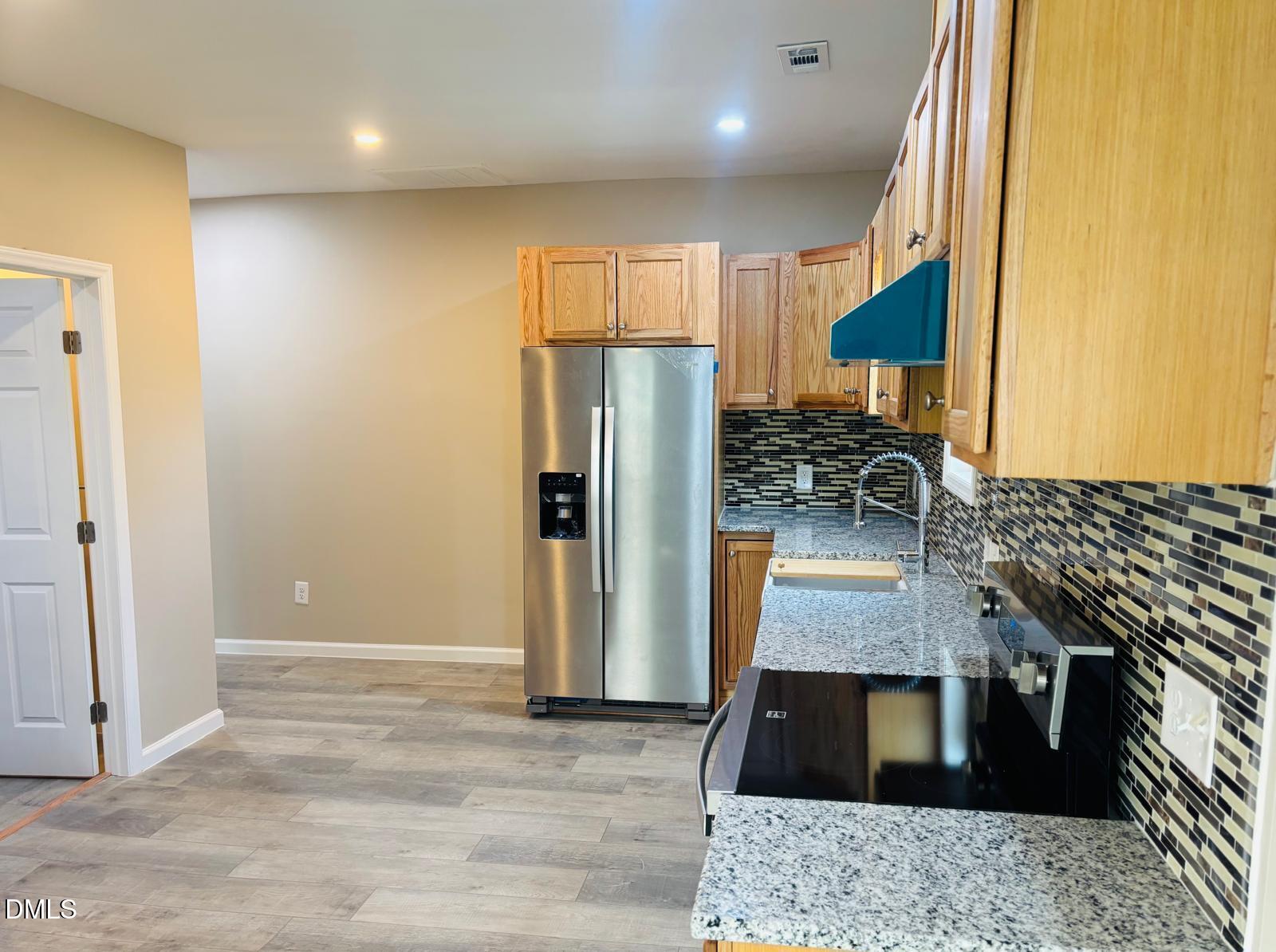 5408 Spence Farm Road, Unit B Holly Springs, NC 27540 - Photo 11 of 19 a kitchen with granite countertop a refrigerator and a stove