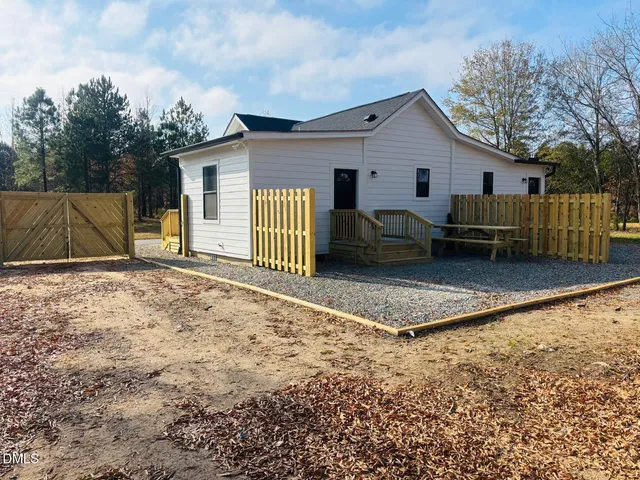 a view of a house with a yard and wooden fence