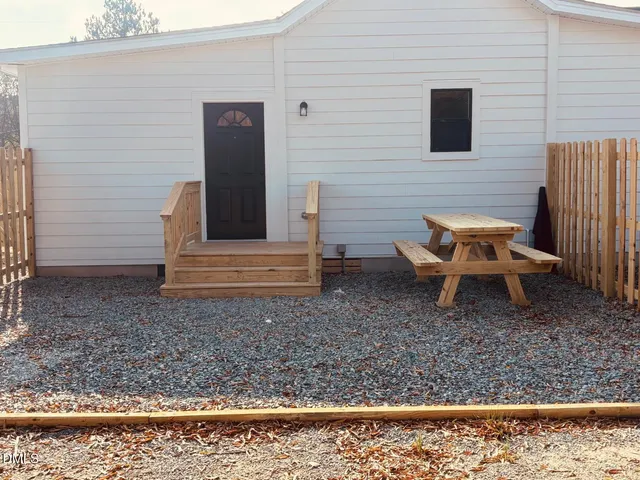a backyard of a house with barbeque oven table and chairs