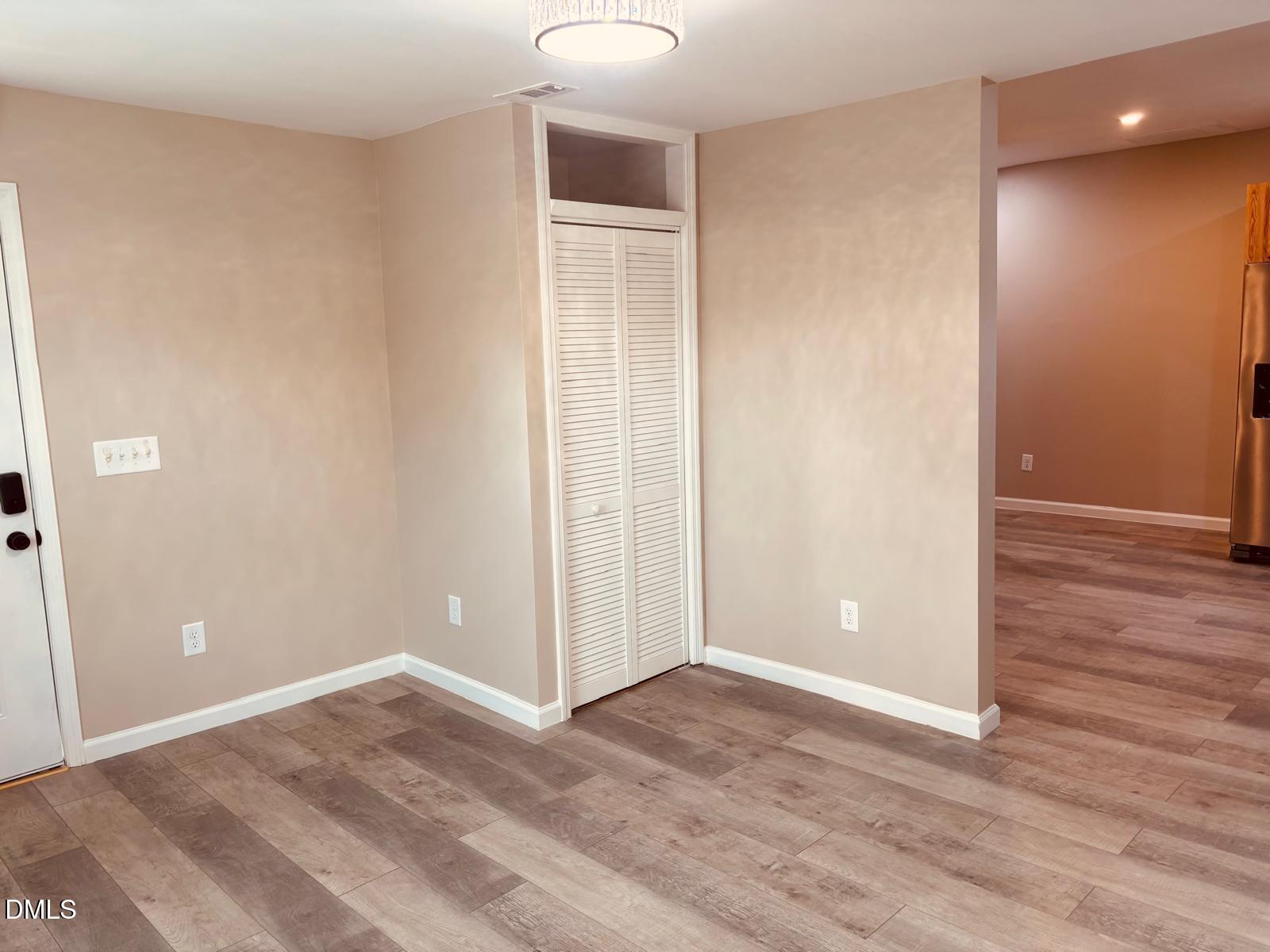 5408 Spence Farm Road, Unit B Holly Springs, NC 27540 - Photo 4 of 19 a view of an empty room with wooden floor and closet