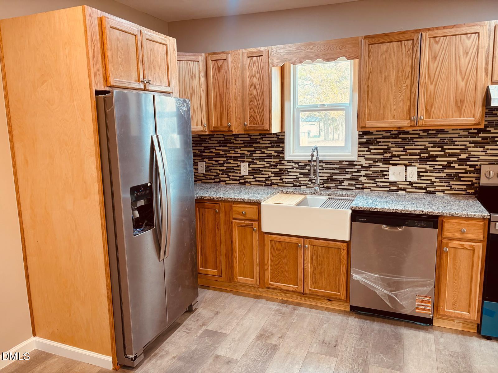 5408 Spence Farm Road, Unit B Holly Springs, NC 27540 - Photo 7 of 19 a kitchen with granite countertop a refrigerator and a sink