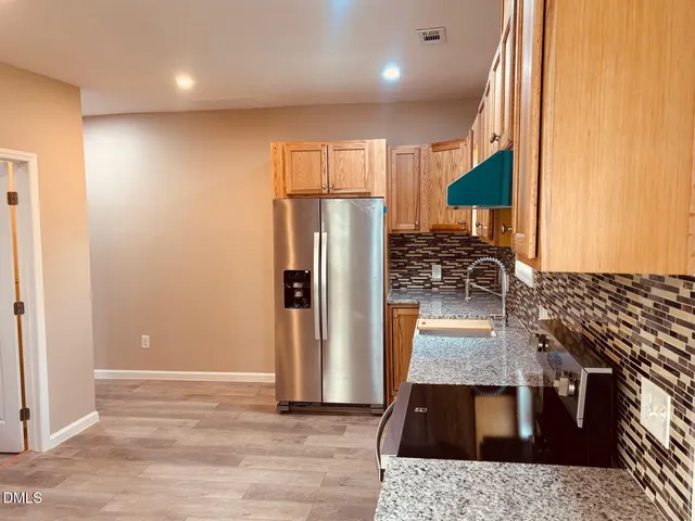 a kitchen with granite countertop a refrigerator and a stove