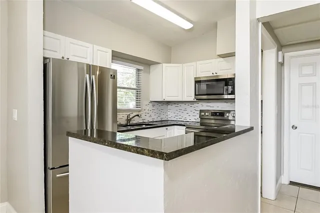 a kitchen with granite countertop a refrigerator and a sink