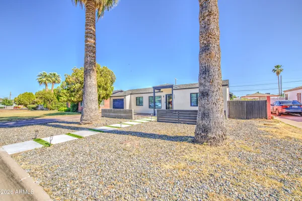 a front view of a house with a yard and trees