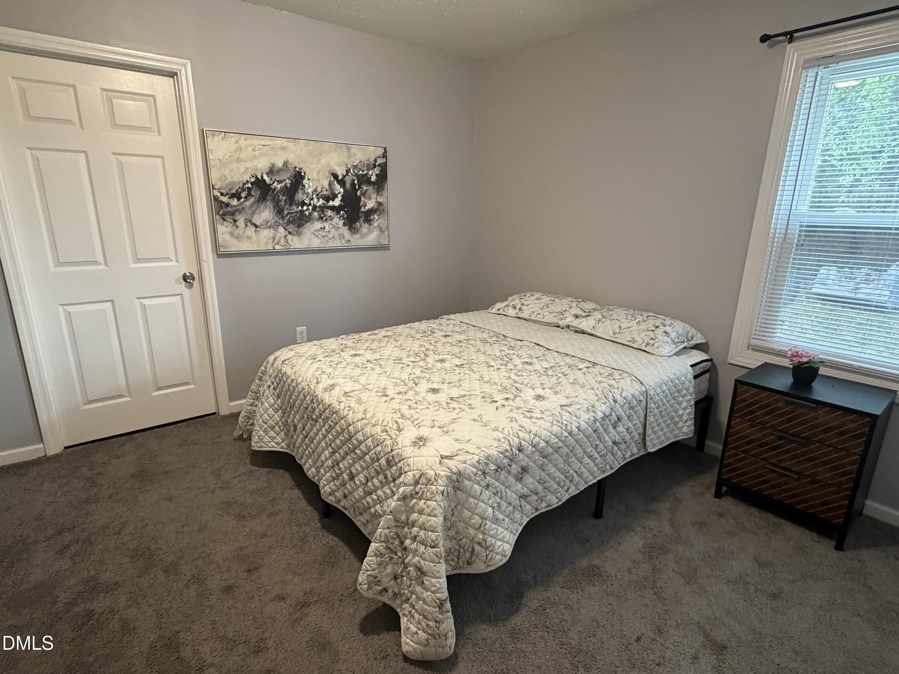 3792 McNeill Hobbs Road Bunnlevel, NC 28323 - Photo 11 of 12 a bed sitting in a bedroom next to a window