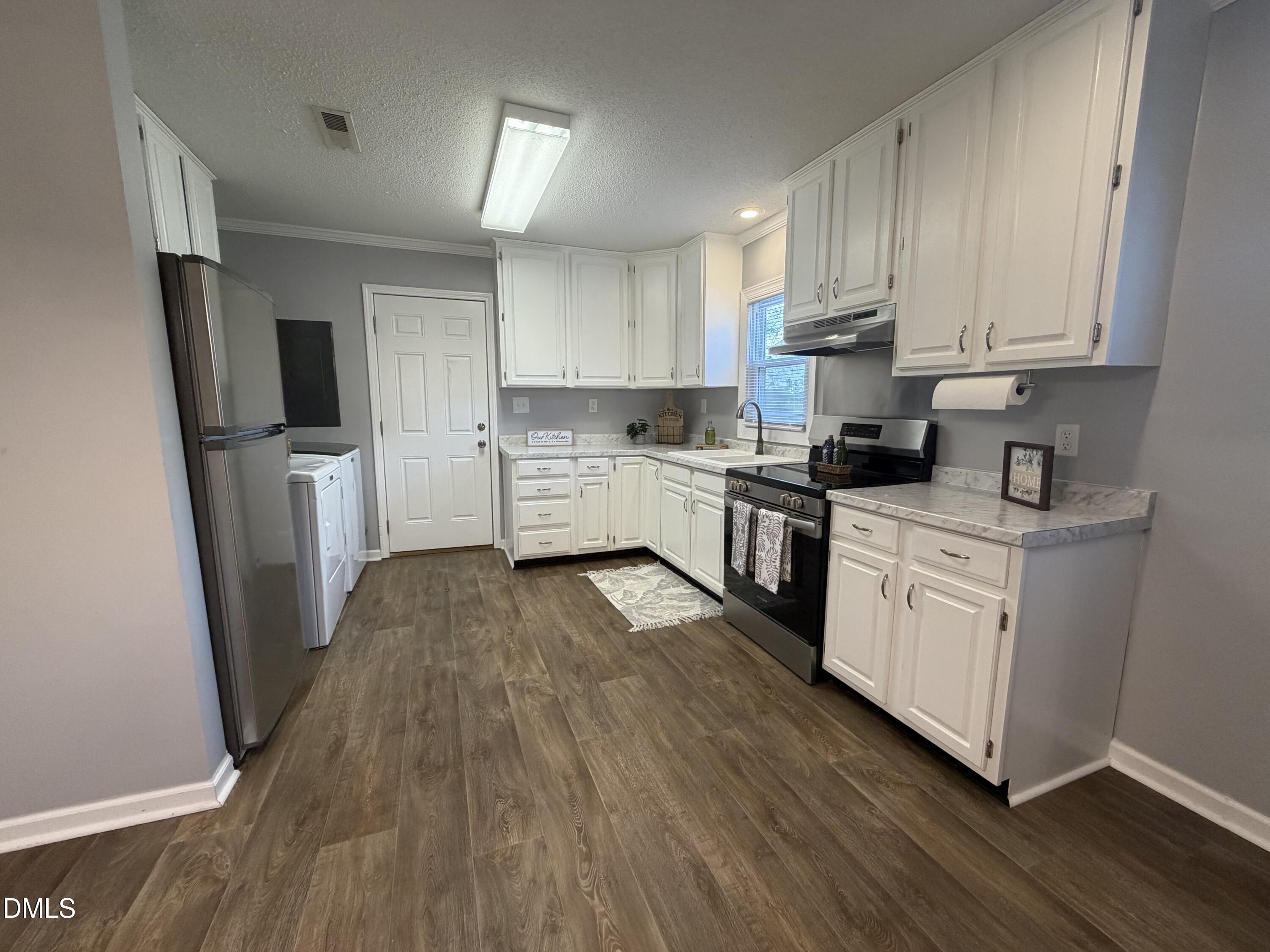 3792 McNeill Hobbs Road Bunnlevel, NC 28323 - Photo 6 of 12 a kitchen with a white cabinets a sink a window and stainless steel appliances