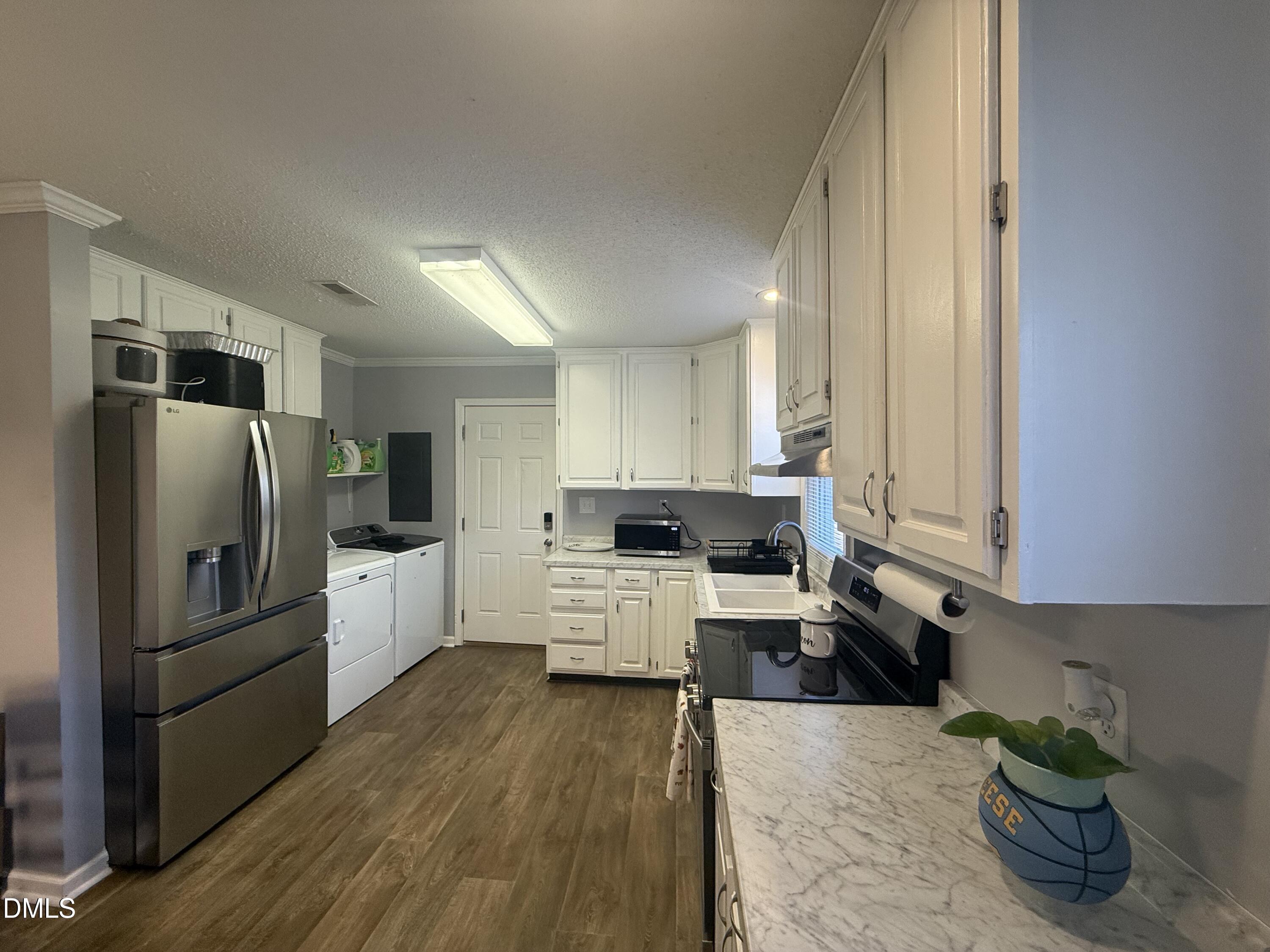 3792 McNeill Hobbs Road Bunnlevel, NC 28323 - Photo 6 of 14 a large kitchen with a large window a refrigerator and stainless steel appliances