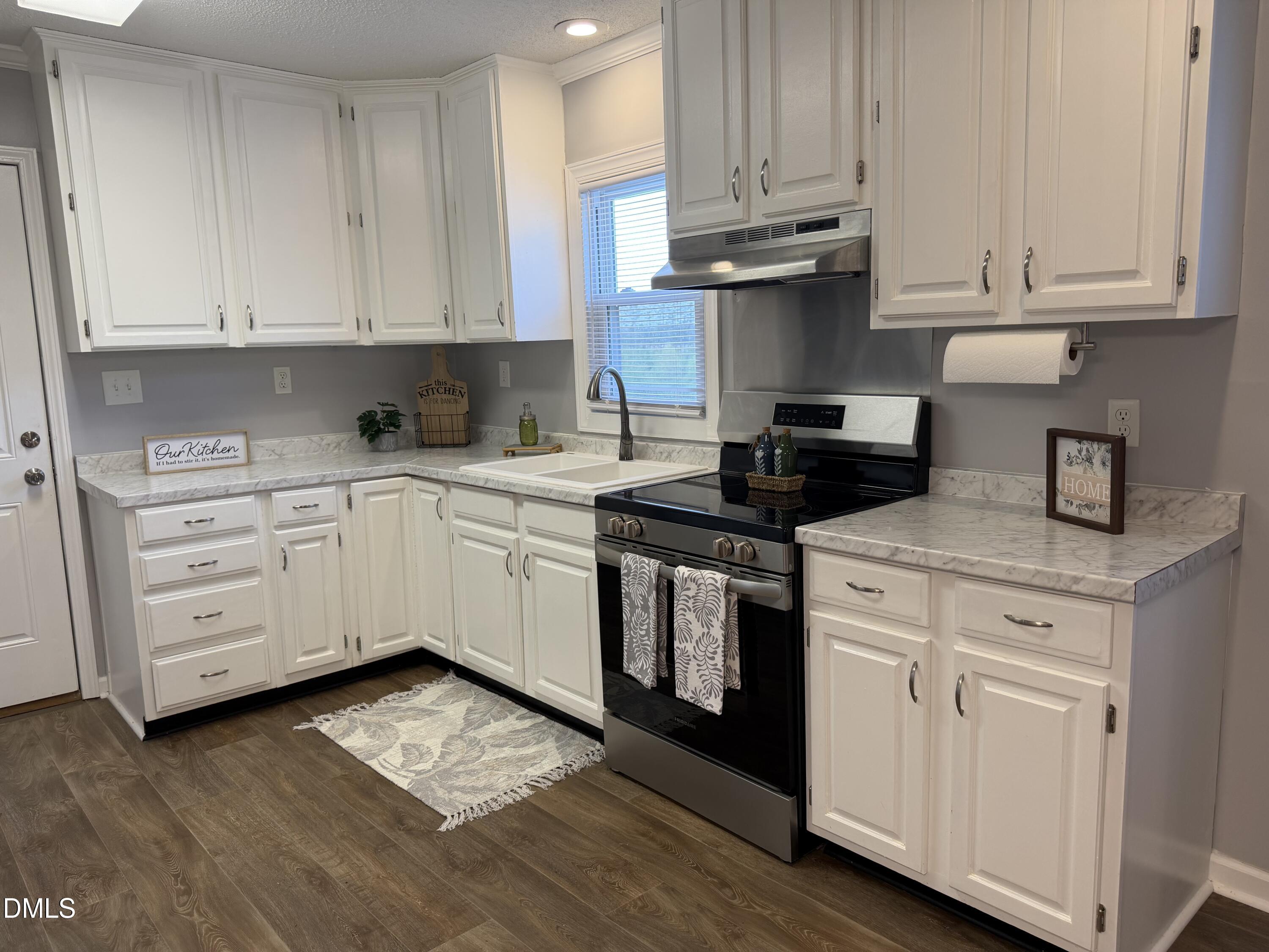 3792 McNeill Hobbs Road Bunnlevel, NC 28323 - Photo 7 of 12 a kitchen with stainless steel appliances granite countertop a stove a sink and white cabinets