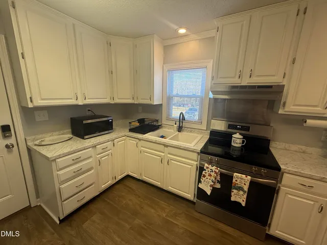 a kitchen with a sink a stove and cabinets