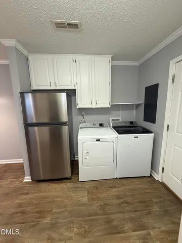 a kitchen with a refrigerator a stove a microwave and white cabinets