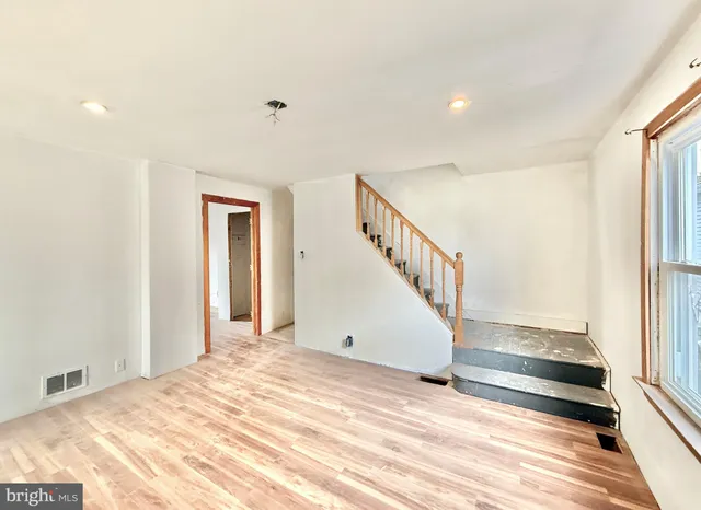 a view of a livingroom with wooden floor and stairs