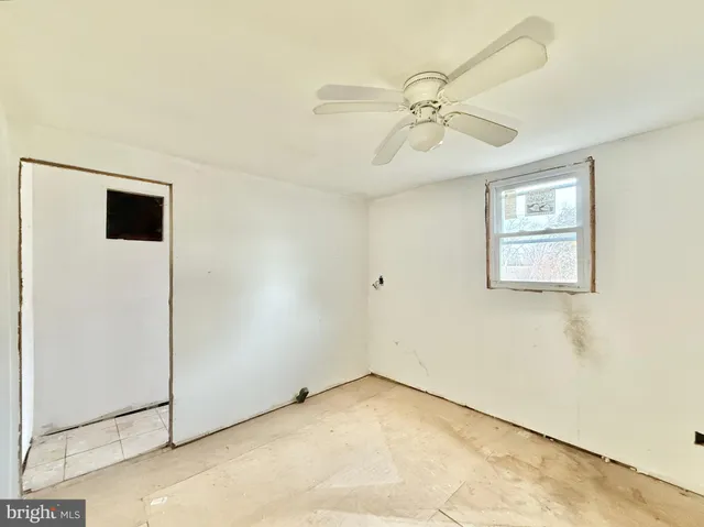 a view of a hallway with closet and a chandelier fan
