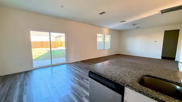 a view of kitchen with granite countertop window and wooden floor